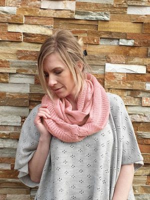A lady standing outdoors wearing a French Rose Pink Branberry Wool Infinity Scarf