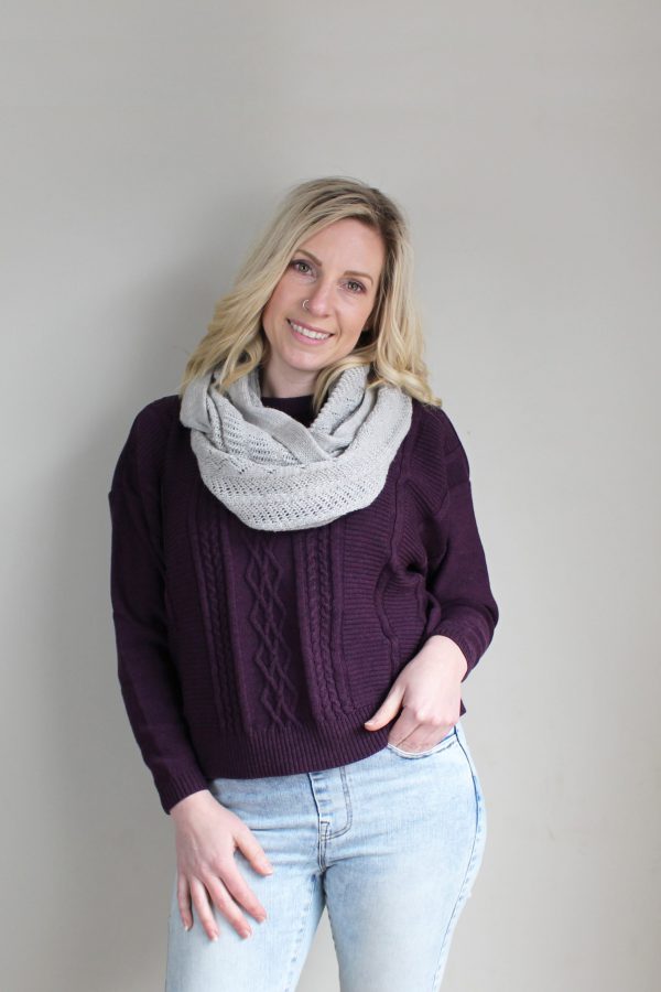 A lady standing indoors wearing a Smoke Light Grey Branberry Wool Infinity Scarf
