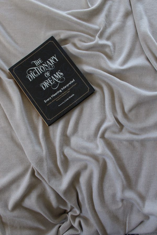 Cashew Merino Wool Blanket in a styled layout, featuring rich texture, with a black book about dreams on top.