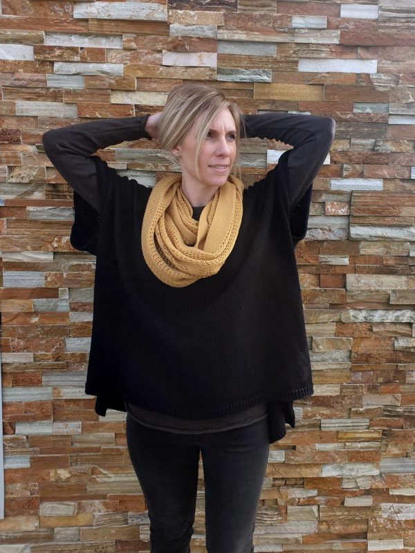 A lady standing and tying up her hair wearing an Mustard Branberry Wool Infinity Scarf