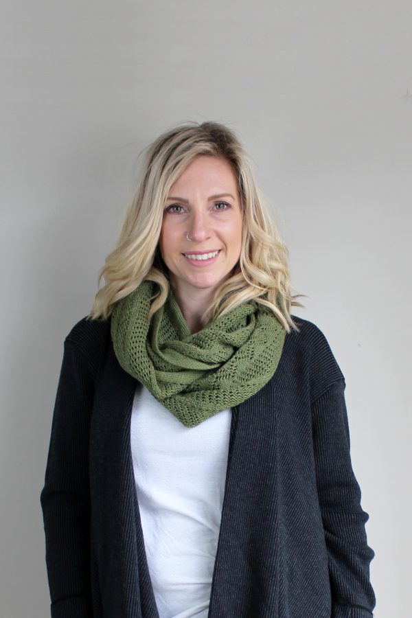 A lady standing indoors wearing a Olive Green Branberry Wool Infinity Scarf