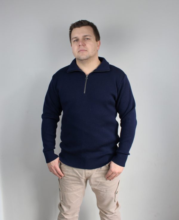 A man standing indoors wearing an Australian Made, pure merino woollen Branberry knitted jumper with zip neck in Navy.
