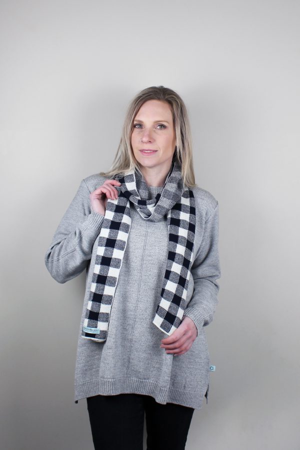 A Lady standing indoors wearing a Branberry Australian Made wool Gingham knitted scarf in Navy and white.