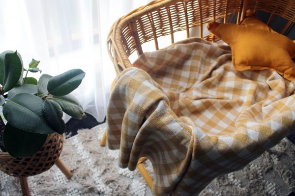 Mustard and White Gingham Blanket made from Pure Australian Merino Wool. Placed in a gorgeous bassinet with star cushion in a nursery, offering warmth and style.