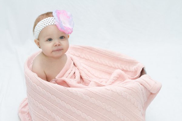 A baby wrapped up in an Branberry Australian Made, Cotton and Merino wool blend Cable Blanket in Pale Pink
