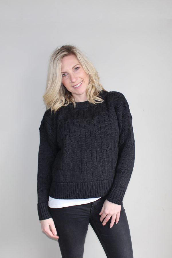 A lady wearing an Australian Made, Branberry merino wool cable crop, crew neck jumper in Black