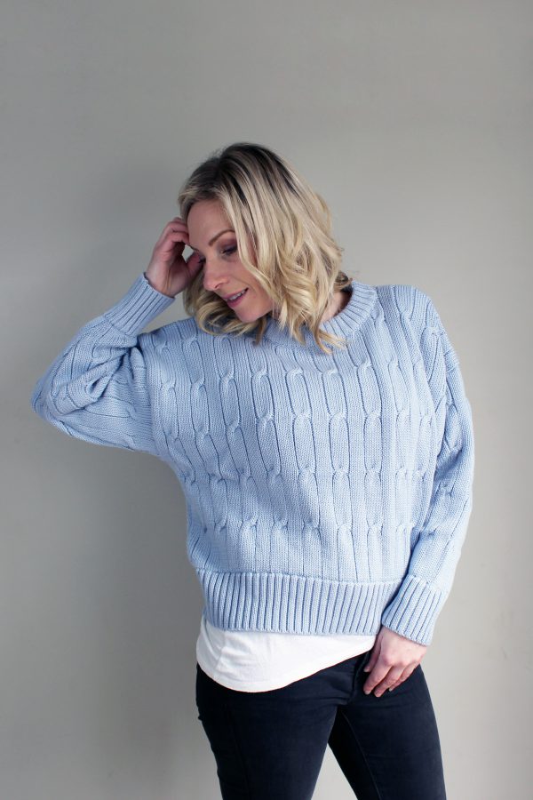 A lady wearing an Australian Made, Branberry merino wool cable crop, crew neck jumper in Powder Blue