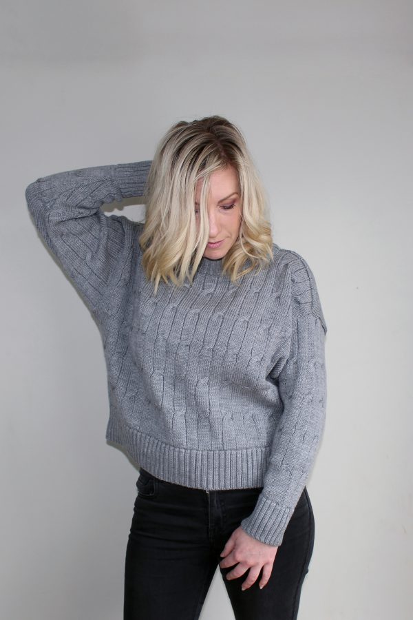 A lady wearing an Australian Made, Branberry merino wool cable crop, crew neck jumper in Silver Grey
