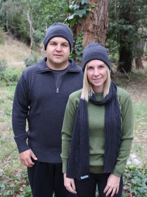 A lady and man stading outside in the bush wearing Interknit Branberry branded Australian made pure merino wool beanies