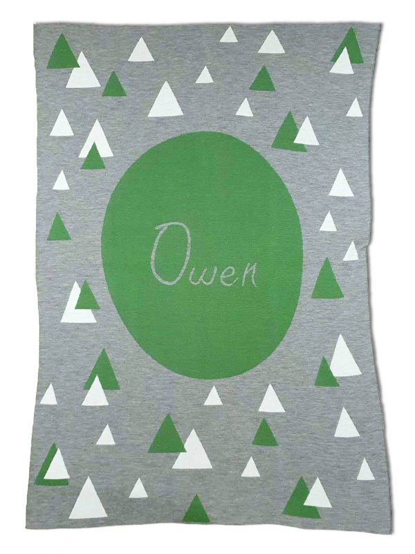 A Personalised Name Blanket with sporadic triangles with a big circle in the centre with a custom name, in a grey, green and white colour combo, product photo. Made from Pure Australian Merino Wool and Made in Australia.