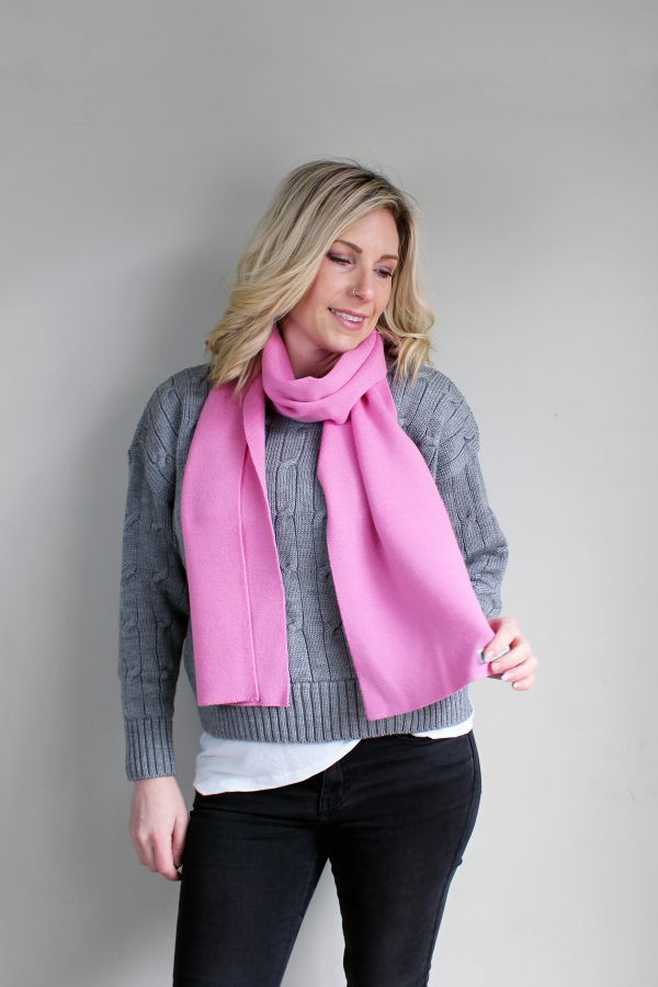 A lady wearing an Australian Made, Plain Adult Unisex Scarf in Taffy Pink, made from Pure Australian Merino Wool