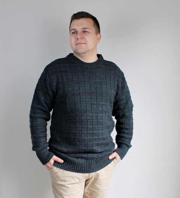 A man wearing Night Forest, Michael Bricks designed jumper, showcasing the intricate knit detail and dark green marl colours.
