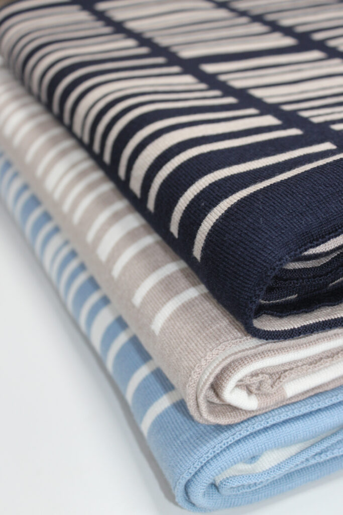 Stacked Adair Wool Blankets in Navy & Cashew, Cashew & White, and Egg Blue & White